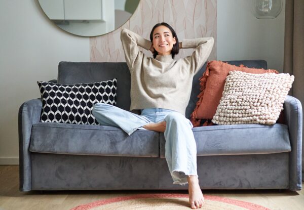Portrait,Of,Happy,Asian,Woman,Feeling,Lazy,,Stretching,On,Sofa
